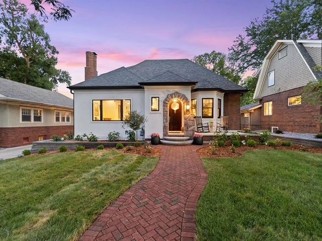 Brick paver walkway and landscaped front yard at dusk