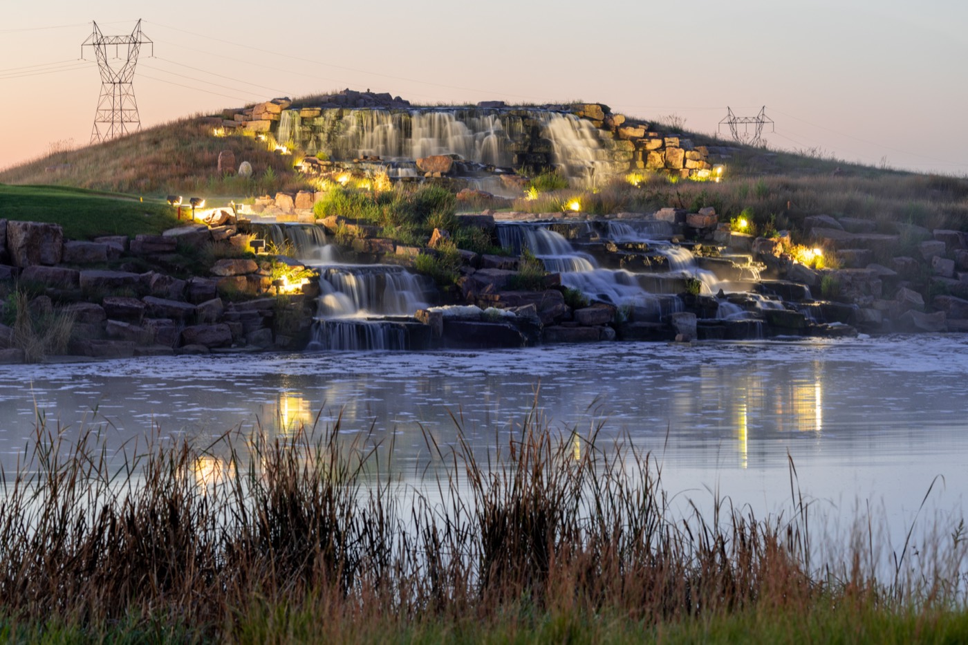 Illuminated multi-tier waterfall over natural stone